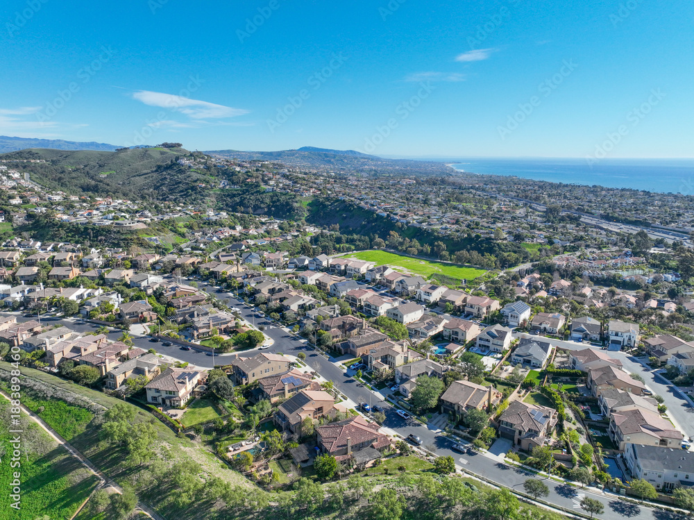 Obraz premium Aerial view over San Juan Capistrano, California, featuring the historic mission, library, sports courts, and an Amtrak train pulling into the downtown station. High quality 4k footage