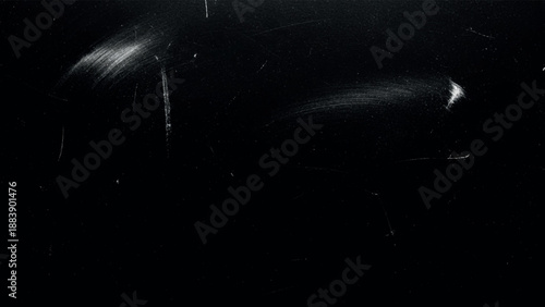 Grainy textured abstract black background with distressed white scratches smudges and rough grunge surface details