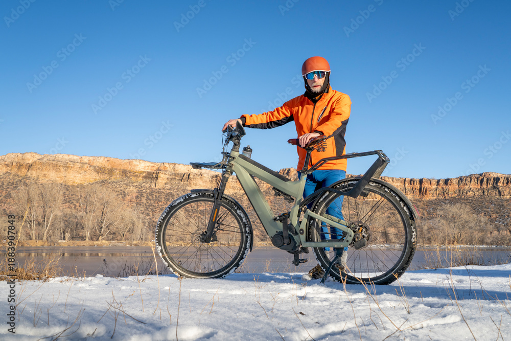 Obraz premium senior male cyclist with a touring electric bike in Colorado foothills in winter scenery