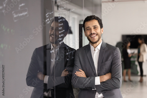 Fotografie Arabic man, project manager stands confidently with arms crossed leaning against