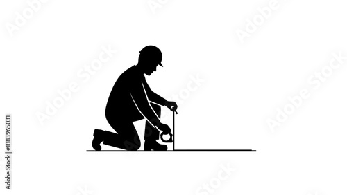 Man kneeling and working with a tool on the ground.