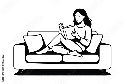 A woman sitting comfortably on a couch reading a book in a relaxed atmosphere