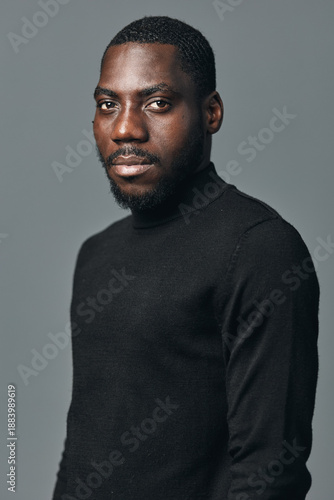 Картината върху платно African man portrait in creative conceptual visual style wearing black turtleneck sweater against gray background