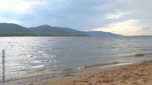 View of the Zhiguli mountains from the sandy shore in cloudy weather. The Volga River.