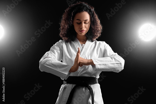 Cuadro en lienzo Young African-American woman practicing karate on dark background