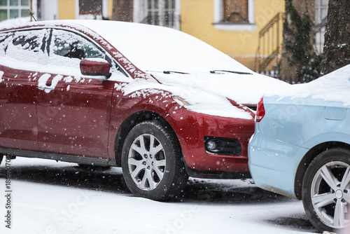 Red car covered with snow o...