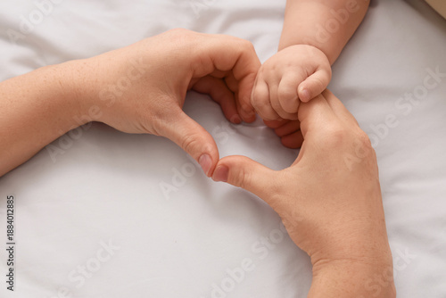 Hands of mother and her lit...