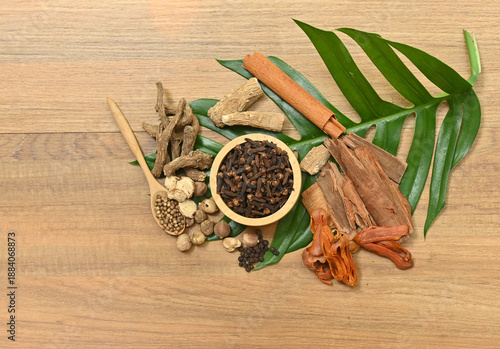 Obraz na plátně Top view assortment of aromatic spices: cloves, cardamom, cinnamon, black pepper, and white pepper, used in cooking and herbal medicine