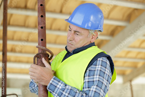 mature builder adjusting acrow prop