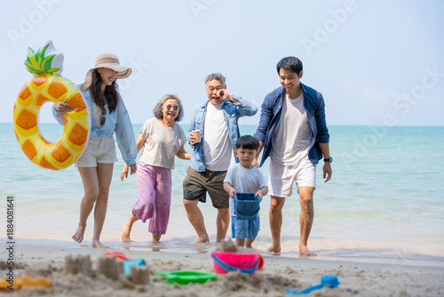 Multi-generational Asian family enjoying summer beach vacation together. Grandparents, parents, and child bonding by the sea, joyful outdoor. family, beach, vacation, summer, multi-generational.