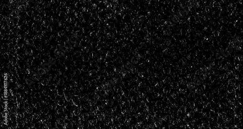 High contrast bubble wrap texture on black background with glowing light reflections. Abstract plastic pattern, futuristic industrial surface, dramatic lighting, creative packaging concept.