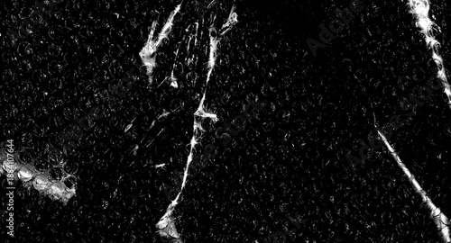 High contrast bubble wrap texture on black background with glowing light reflections. Abstract plastic pattern, futuristic industrial surface, dramatic lighting, creative packaging concept.