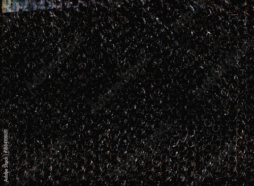 High contrast bubble wrap texture on black background with glowing light reflections. Abstract plastic pattern, futuristic industrial surface, dramatic lighting, creative packaging concept.