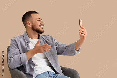 Smiling young man sitting i...