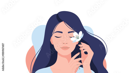 Serene young woman with long dark hair keeps her eyes closed while holding a delicate white flower to her face in a moment of peace.