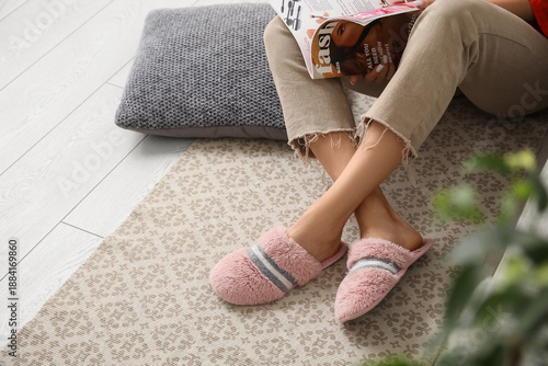 Young woman in slippers rea...
