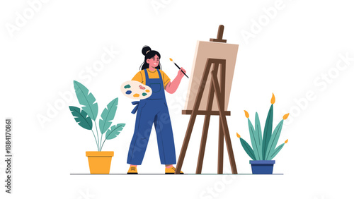 Talented young woman artist in denim overalls painting on a canvas with a wooden easel surrounded by indoor potted plants in her studio.