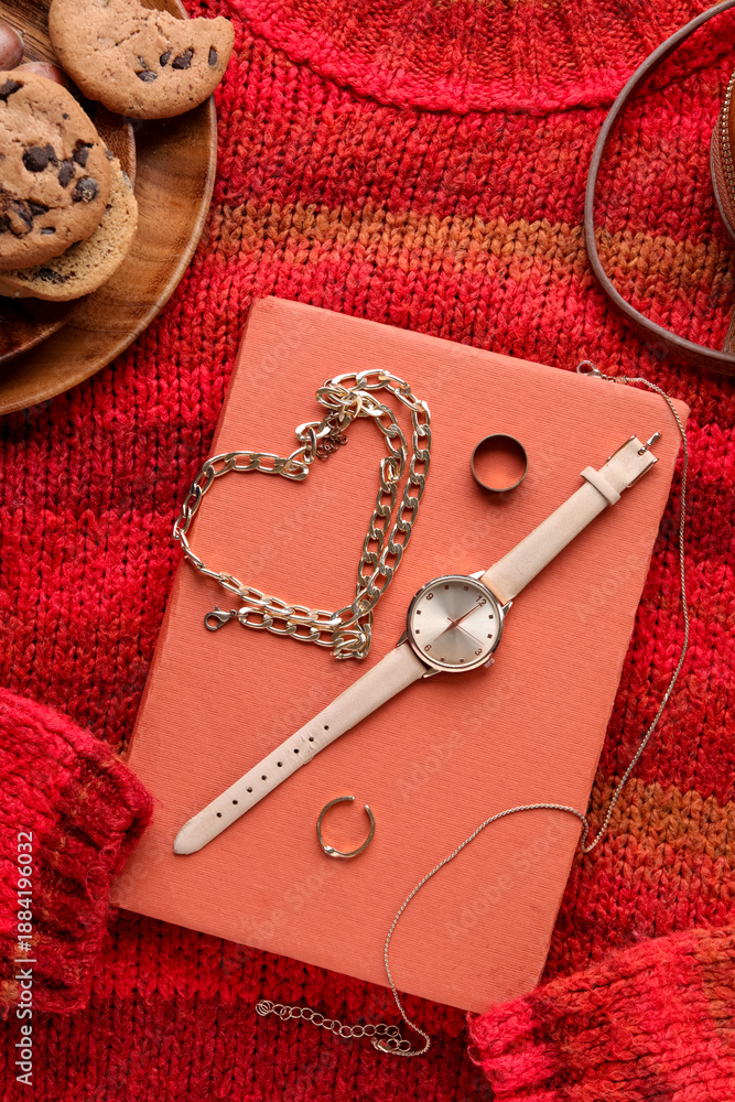 Fototapeta premium Composition with stylish female accessories, book and cookies on knitted sweater