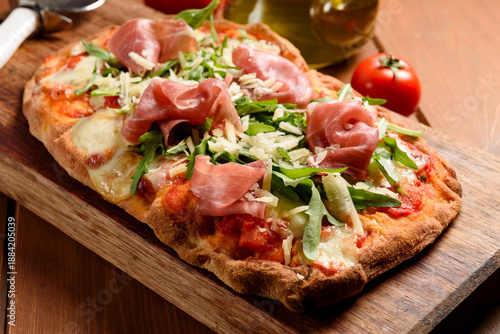 Pinsa romana con rucola, prosciutto crudo e scaglie di parmigiano, cibo italiano 