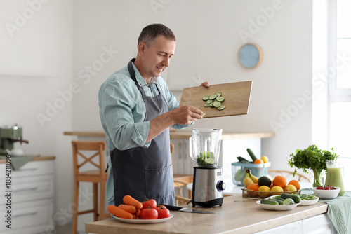 Mature man putting cucumber...