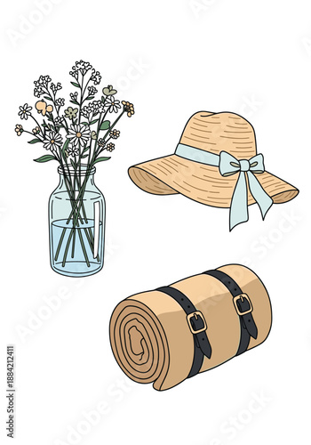 Simple collection of items for an outdoor outing including a glass vase of wildflowers, a straw sun hat, and a rolled picnic blanket.