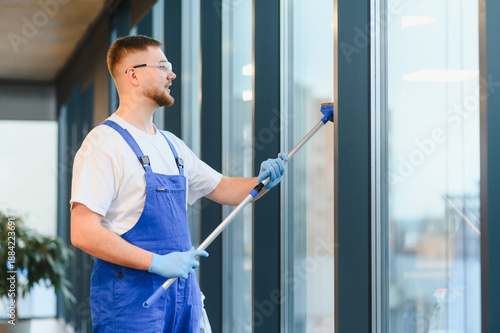 Fotografie Professional window cleaner washing office building glass