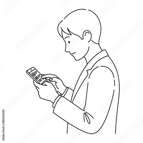 A man holding a remote control in his hands, standing and looking at it with a slight smile