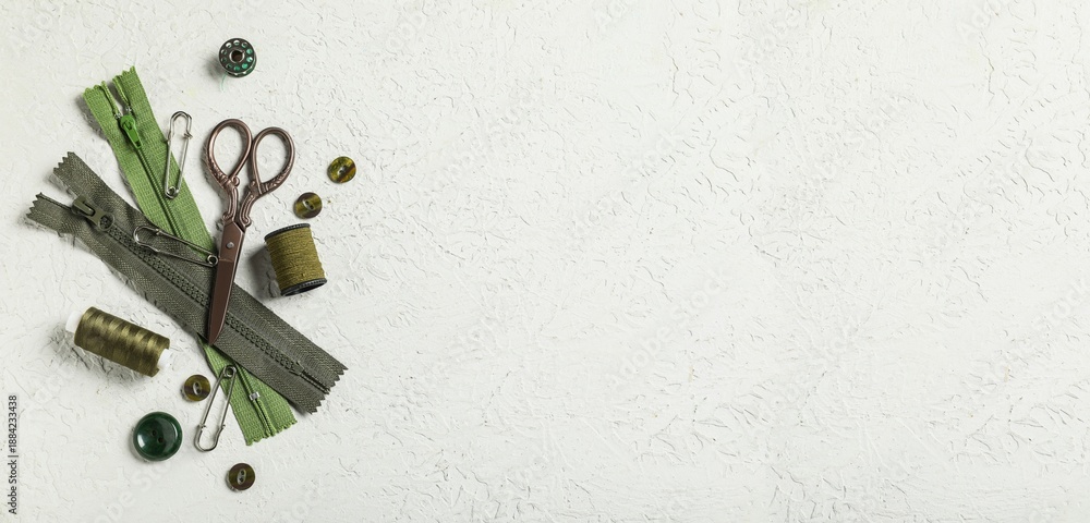 Obraz premium Different tailor's supplies with measuring tape on white grunge background with space for text