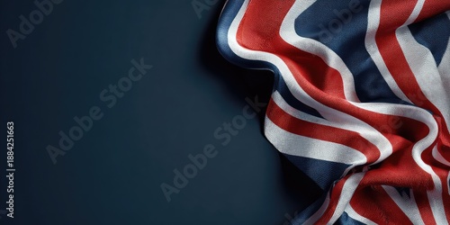 A close-up of a flag, draped, with red, white, and blue stripes. Navy blue background