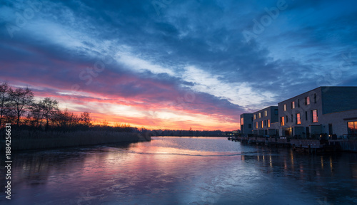 A colourful dawn in modern neighbourhood at the waterfront. Meerstad, the Netherlands.