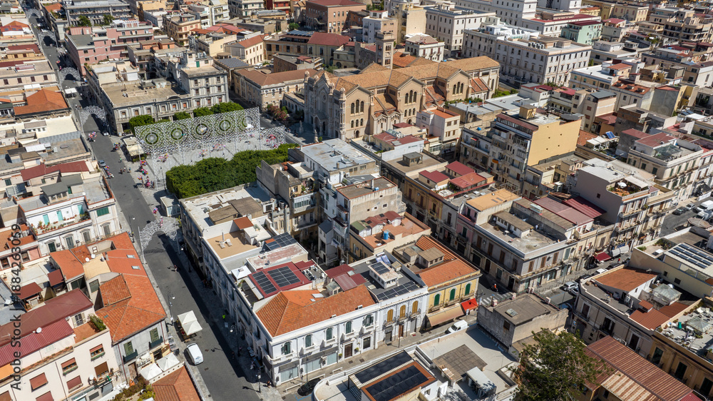 Fototapeta premium High-angle aerial view of a historic city square with a large cathedral. It is the Reggio Calabria Cathedral, Italy. It is a Roman Catholic basilica in the historic center of the city.