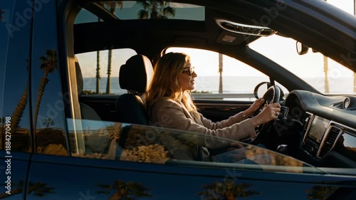Wallpaper Mural Woman driving car along the coast during sunset with palm trees visible in the reflection of the windows Torontodigital.ca