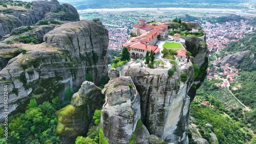 Aerial drone footage orbiting the Monastery of the Holy Trinity in Meteora, Greece. Cinematic close-up of the iconic UNESCO World Heritage site perched on a dramatic cliff rock