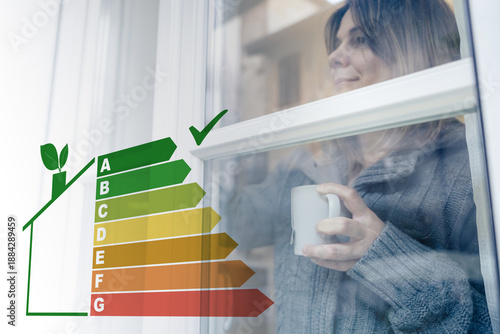 Tableau sur toile Woman with a warm mug looks through an energy efficient window featuring an over