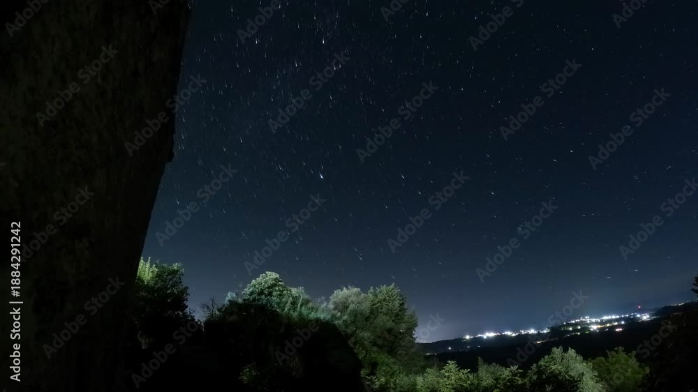 Night Sky Star Trails Time Lapse Over Forest Silhouette and Distant ...