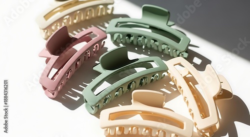Set of colorful matte hair claw clips on white table, pastel plastic hair claw clips fashion accessories, trendy Korean style hair claw clips in sunlight.
