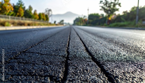 Wallpaper Mural Close-up view of a cracked asphalt road leading towards distant mountains. Torontodigital.ca