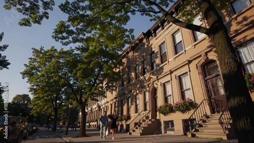 Wallpaper Mural Charming street view video of classic brownstone buildings with lush trees, captured from a low angle under a clear blue sky. Torontodigital.ca