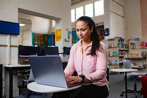 Maori woman studying and working with a laptop at a public library