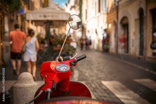 Red scooter parked on a charming cobblestone street in a European city, with pedestrians and café in the background. Rome Italy