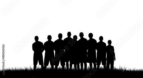 Football players in silhouette on the grass of a field.