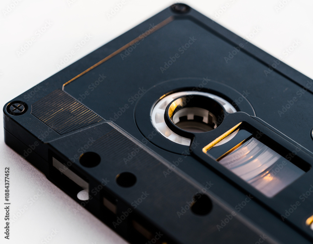 Obraz premium High-Angle Macro of a Vintage Black Audio Cassette Tape on a White Minimalist Background