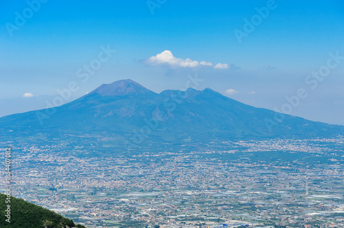 Wallpaper Mural Telephoto view of Mount Vesuvius volcanic cone and crater summit rising above dense Naples metropolitan area urban sprawl under clear blue summer sky with white clouds Torontodigital.ca