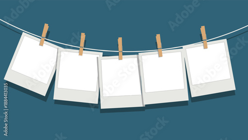 Row of five blank white instant photo frames hanging on a wire with wooden clothespins against a dark blue background.