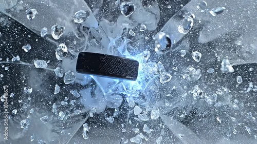 Hockey puck smashing through frozen ice in slow motion