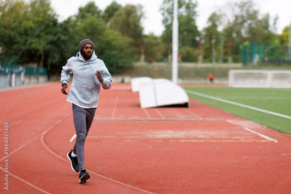 Obraz premium Black man running on athletic track outdoors