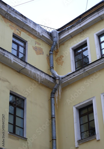 Icicles on the cornice and downpipe of the building's inner corner