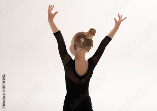 Child dancer with cochlear implant raising arms in expressive movement. Hearing impairment treatment, auditory rehabilitation, assistive technology, physical therapy, and confidence empowerment
