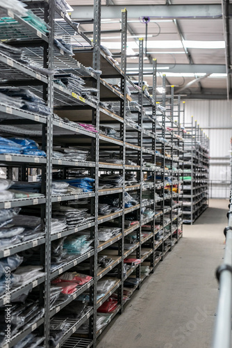 Industrial warehouse interior with metal shelves used for organised storage and picking of garments or stock
