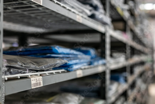 Industrial warehouse interior with metal shelves used for organised storage and picking of garments or stock